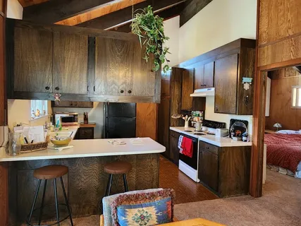 a kitchen with stainless steel appliances kitchen island granite countertop a table chairs sink and cabinets