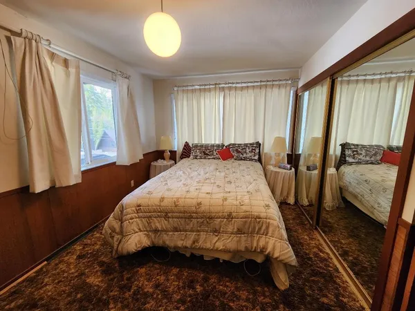 a bed sitting in a bedroom next to a window