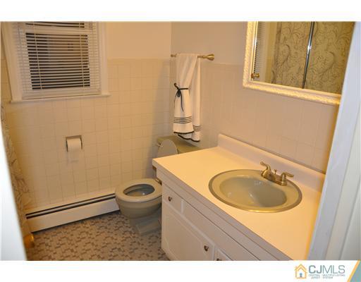 30 Warwick Road Edison, NJ 08820 - Photo 15 of 16 a bathroom with a sink a toilet and mirror