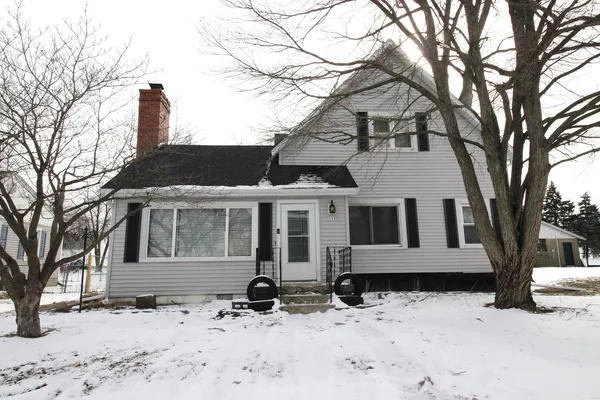 a front view of a house with a yard covered in snow