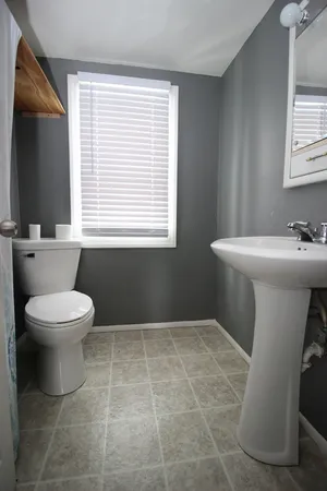 a bathroom with a toilet sink and mirror