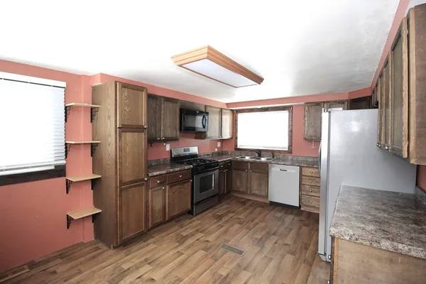 a kitchen with stainless steel appliances granite countertop a refrigerator and a stove top oven