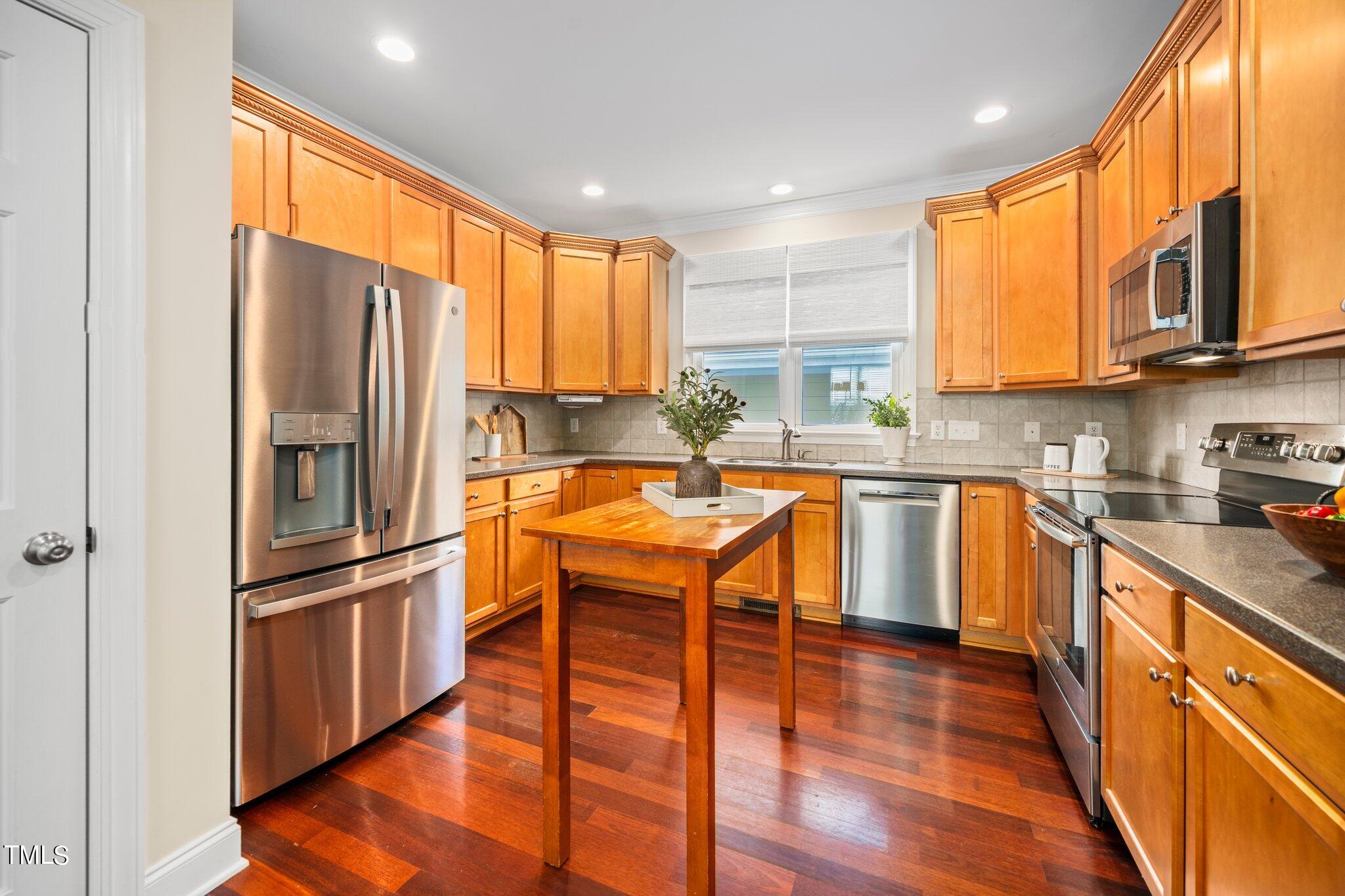 222 Homegate Circle Apex, NC 27502 - Photo 11 of 33 a kitchen with stainless steel appliances granite countertop a refrigerator a sink dishwasher a stove and white countertops with wooden floor