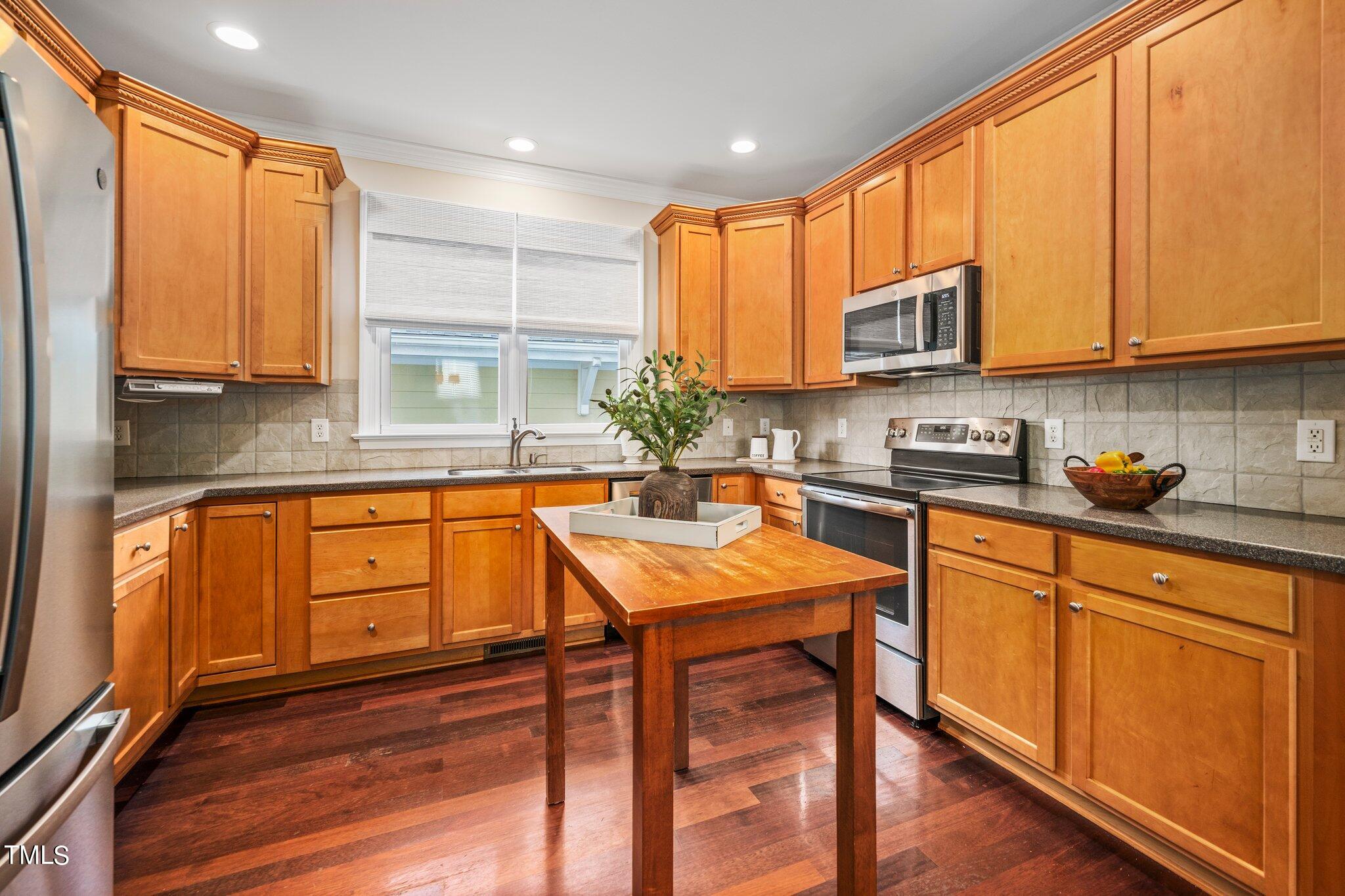 222 Homegate Circle Apex, NC 27502 - Photo 13 of 33 a kitchen with stainless steel appliances granite countertop wooden cabinets a sink and a stove