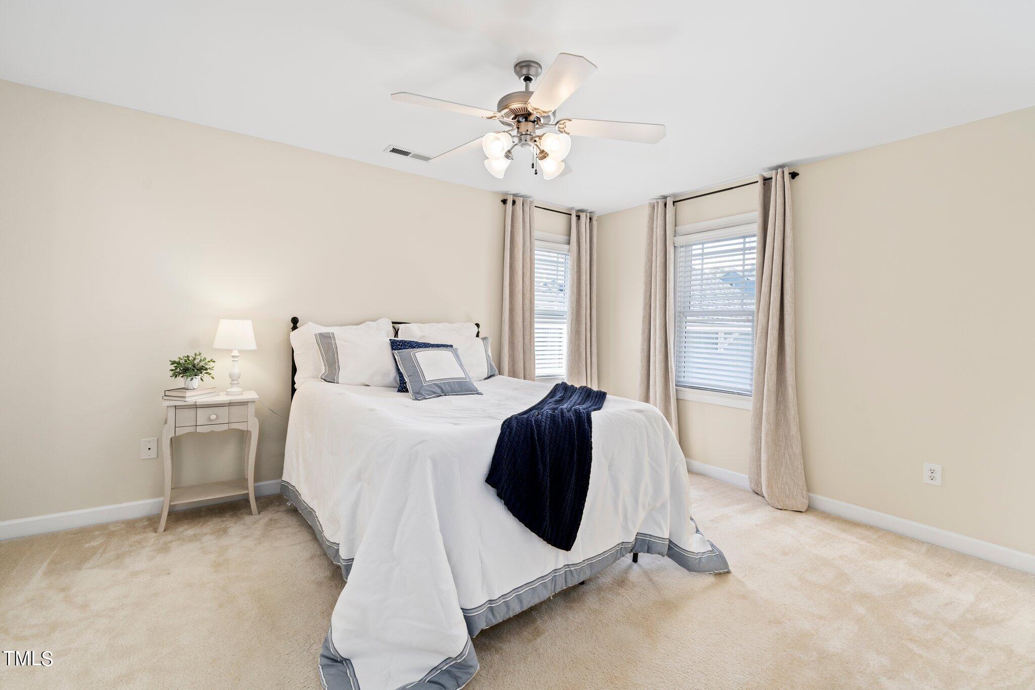 222 Homegate Circle Apex, NC 27502 - Photo 15 of 33 a bedroom with a bed and a chandelier