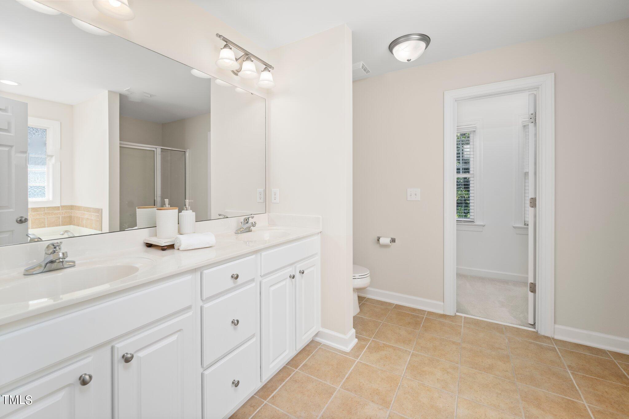 222 Homegate Circle Apex, NC 27502 - Photo 16 of 33 a spacious bathroom with a double vanity sink mirror and