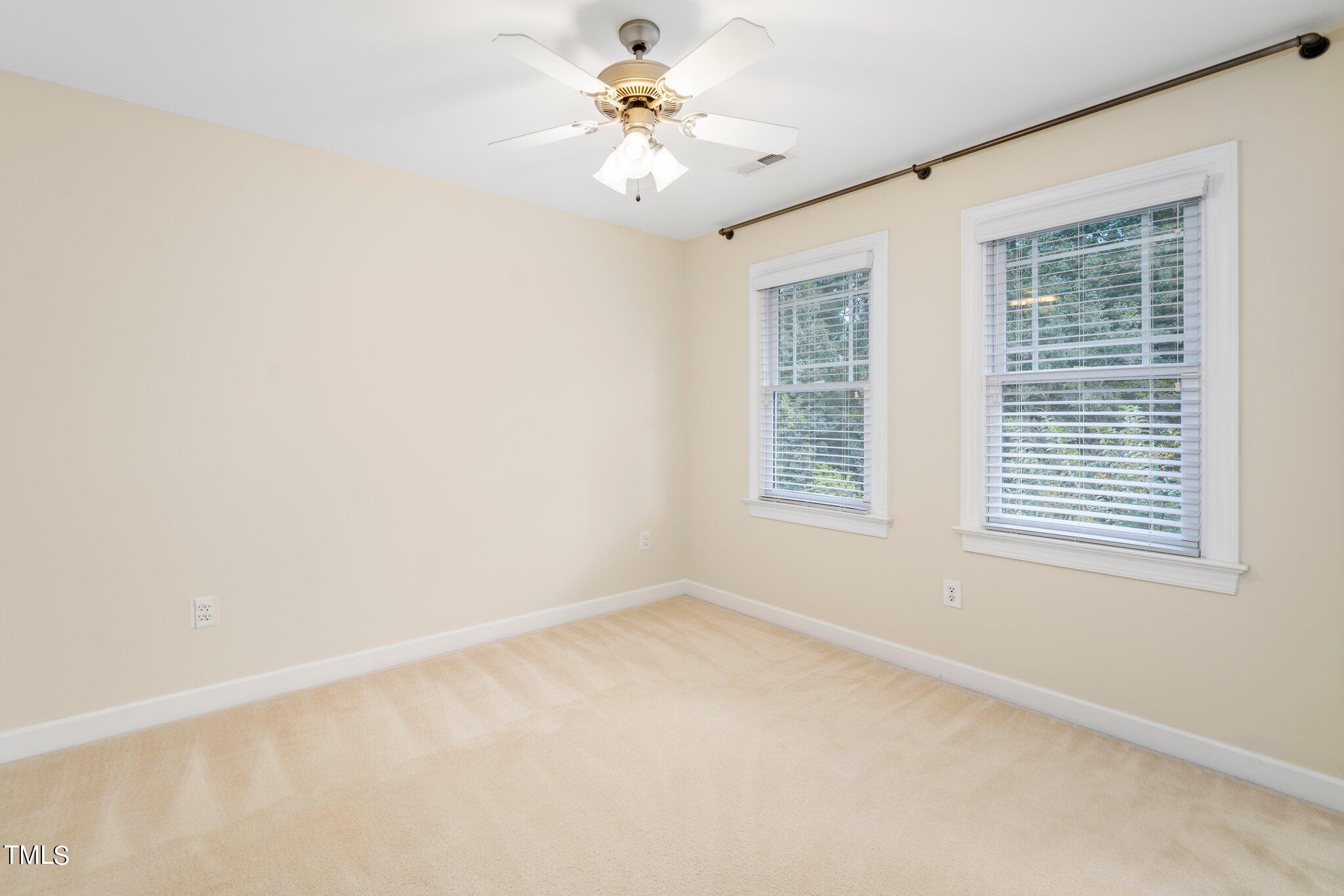 222 Homegate Circle Apex, NC 27502 - Photo 20 of 33 an empty room with windows and chandelier fan