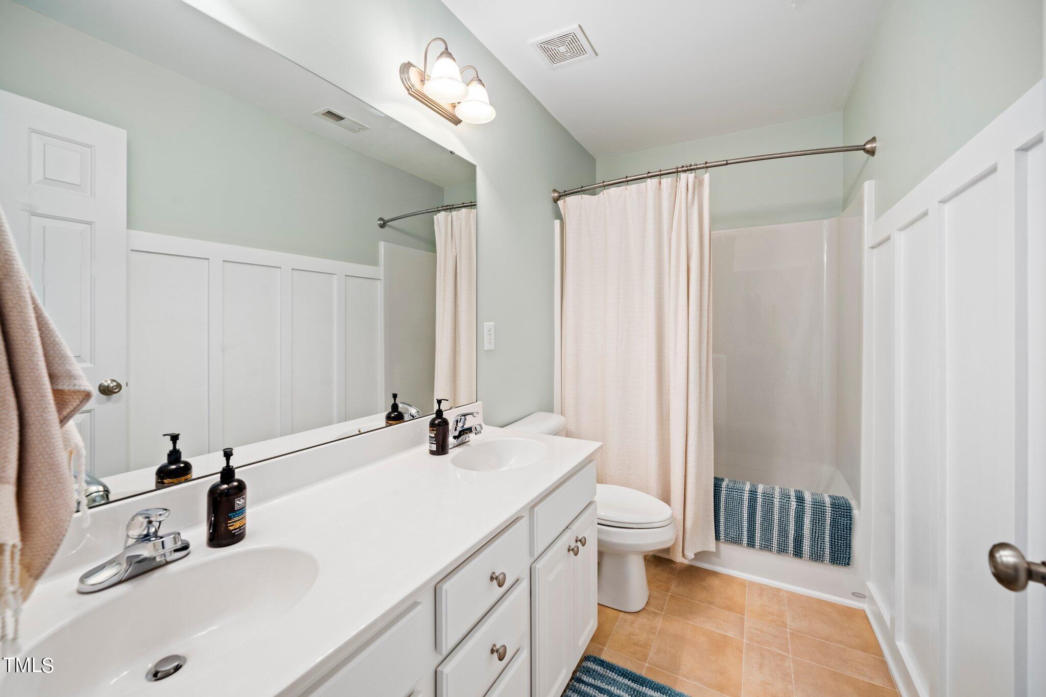 222 Homegate Circle Apex, NC 27502 - Photo 21 of 33 a bathroom with a double vanity sink toilet and shower
