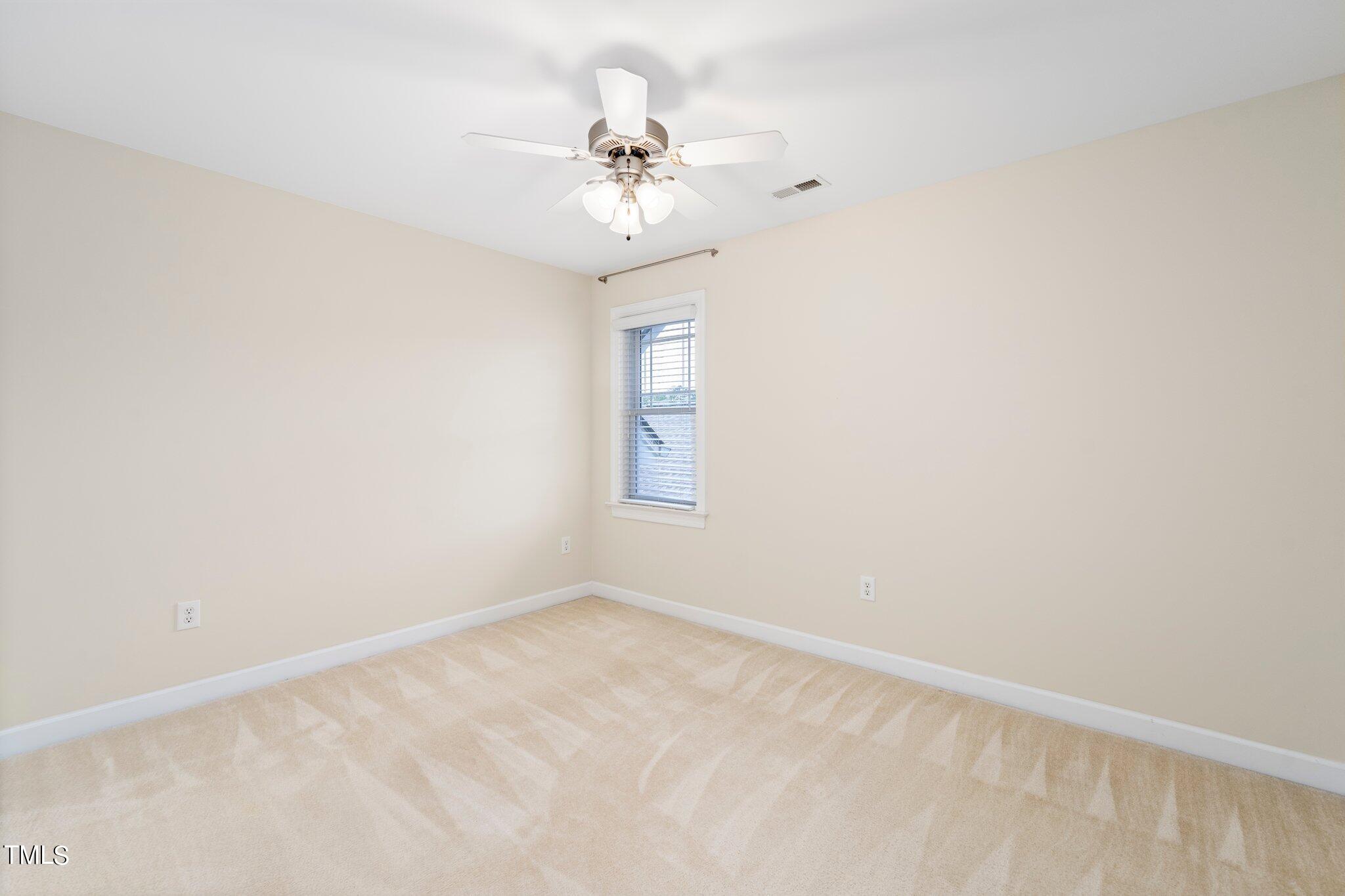 222 Homegate Circle Apex, NC 27502 - Photo 22 of 33 an empty room with a chandelier fan and windows