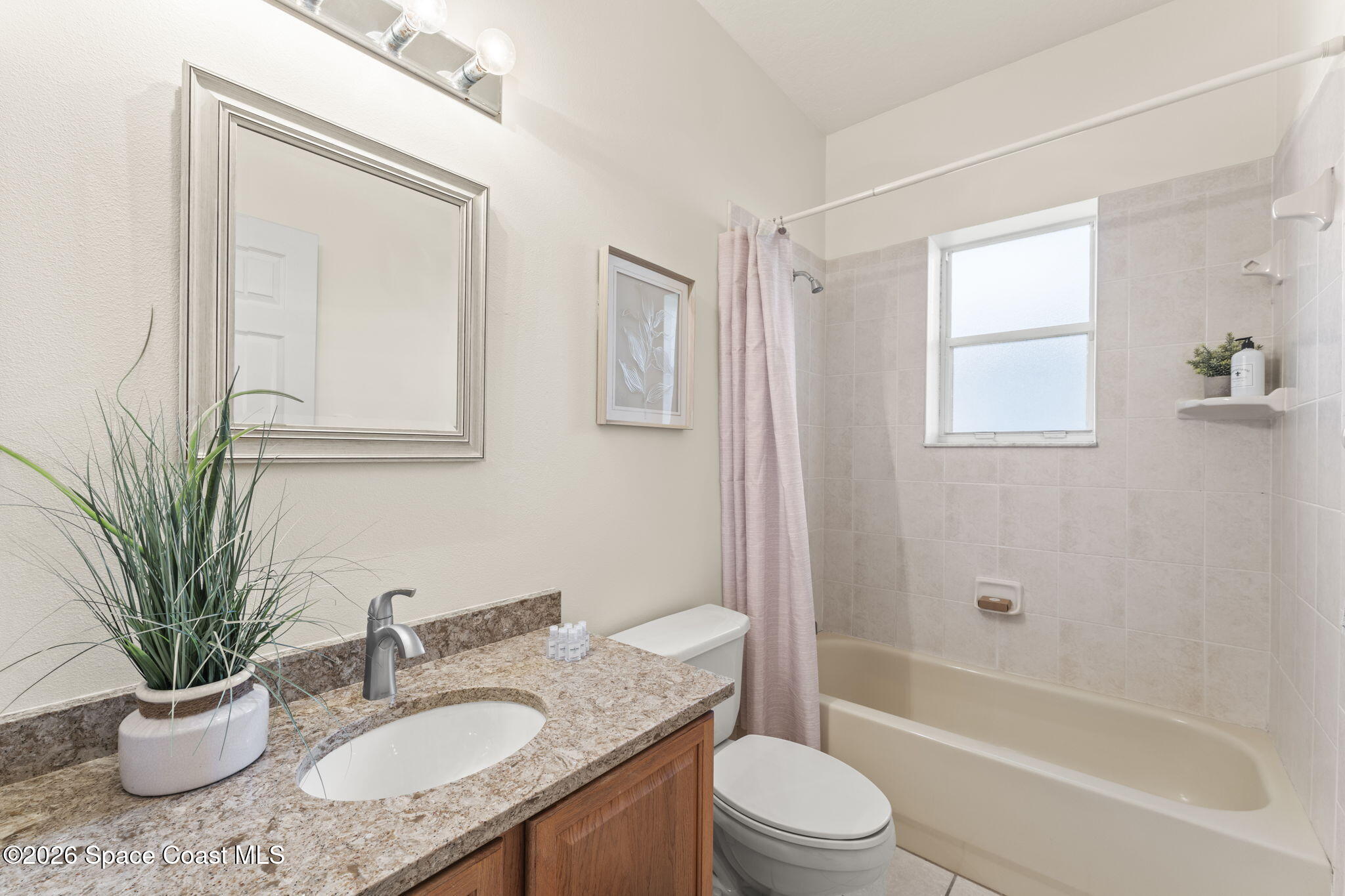 1123 Spring Oak Drive Melbourne, FL 32901 - Photo 48 of 67 a bathroom with a granite countertop sink toilet a mirror a vanity and bathtub