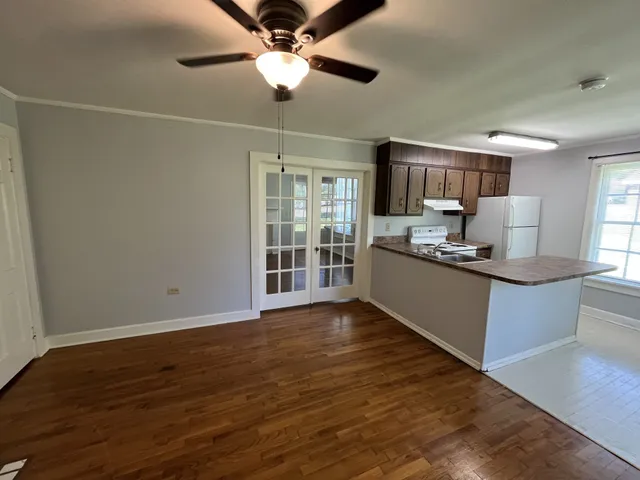 a kitchen with kitchen island granite countertop a sink cabinets and stainless steel appliances