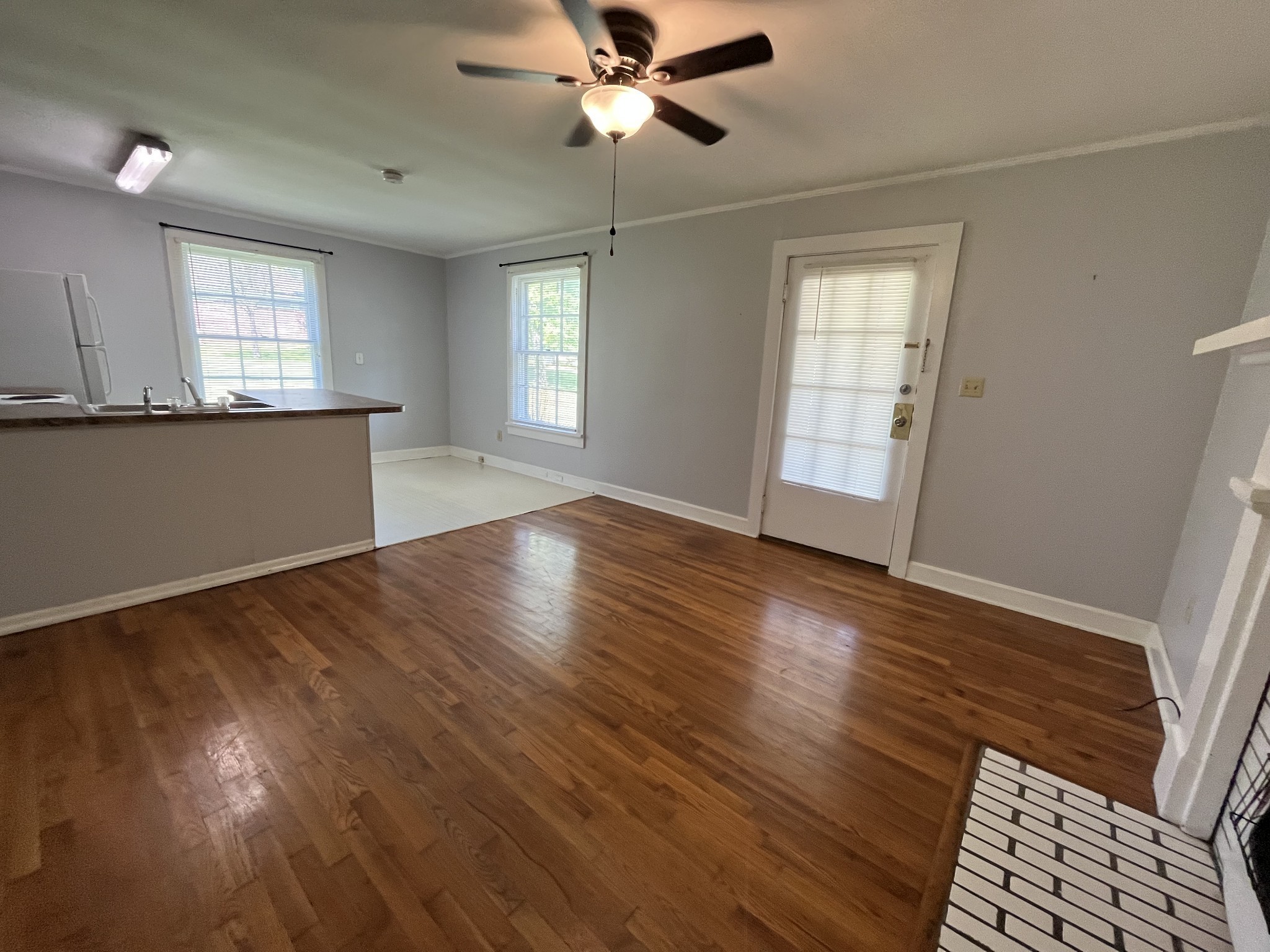437 East Jefferson Street Pulaski, TN 38478 - Photo 2 of 11 a view of an empty room with wooden floor and a window