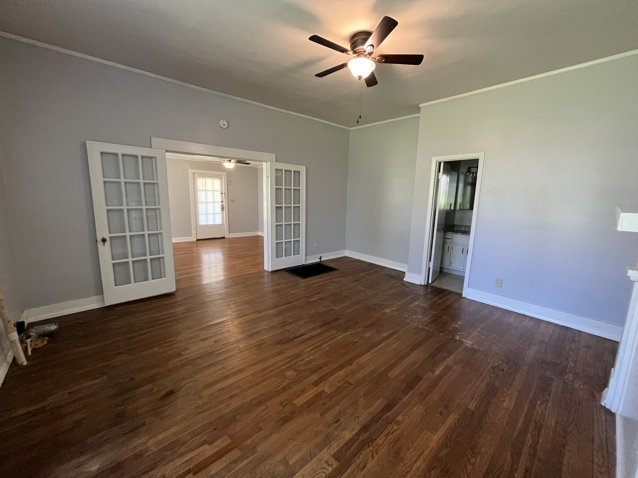 437 East Jefferson Street Pulaski, TN 38478 - Photo 8 of 11 an empty room with wooden floor chandelier fan and windows