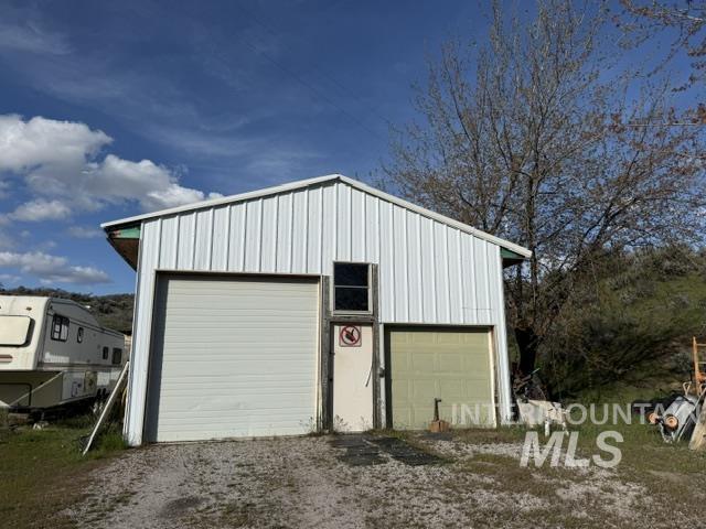 140 Brownlee Loop Road Horseshoe Bend, ID 83629 - Photo 7 of 29 Metal-sided structure with a gabled roof, featuring two garage doors and a central service door