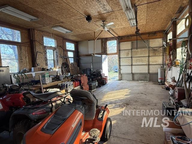 140 Brownlee Loop Road Horseshoe Bend, ID 83629 - Photo 8 of 29 Spacious garage with exposed wood-finish walls and ceilings, concrete flooring, multiple windows, and fluorescent lighting fixtures