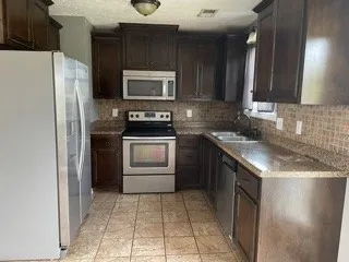 a kitchen with a sink stove and refrigerator