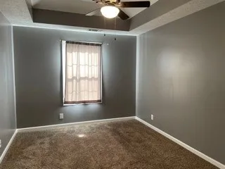 an empty room with windows and fan