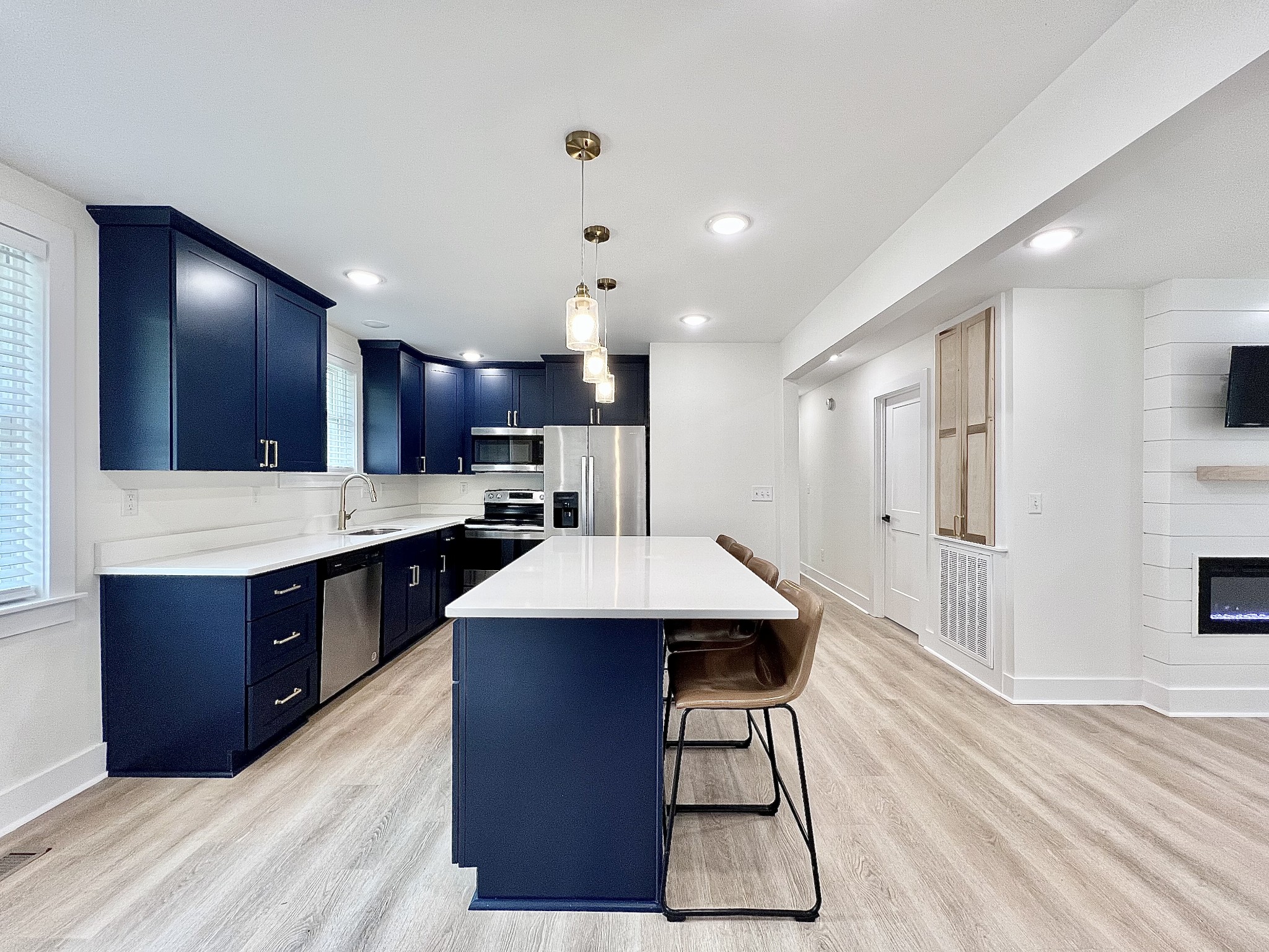 a kitchen with stainless steel appliances kitchen island granite countertop a table chairs in it and wooden floors