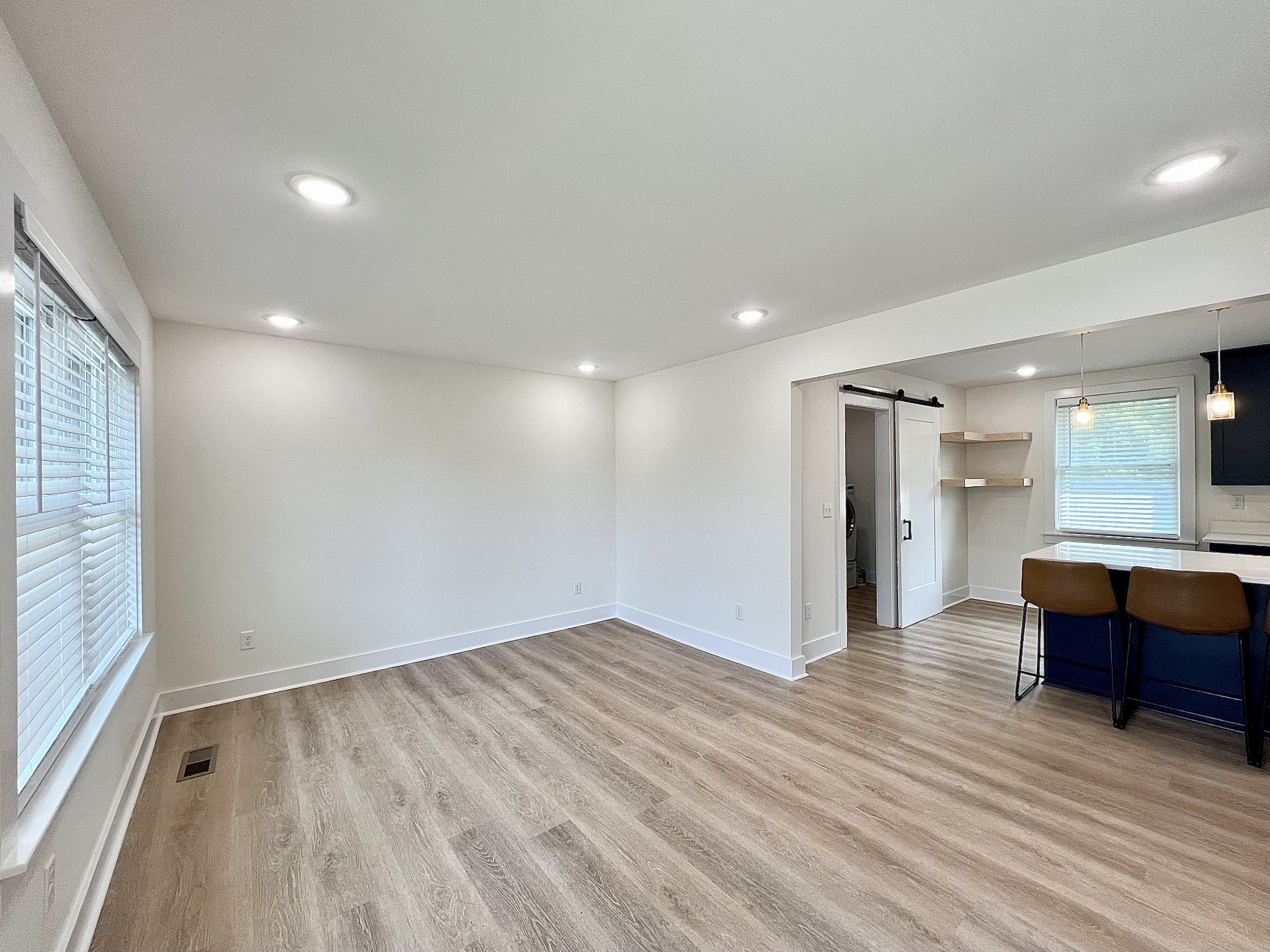 207 North Cedar Lane Pulaski, TN 38478 - Photo 4 of 66 an empty room with kitchen view and wooden floor