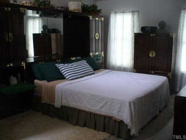 3404 Singleleaf Lane Raleigh, NC 27616 - Photo 4 of 4 a bedroom with a bed and cabinets