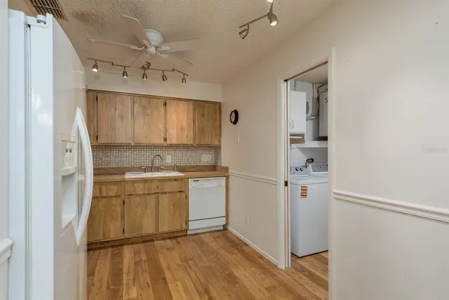 a kitchen with kitchen island white cabinets and refrigerator