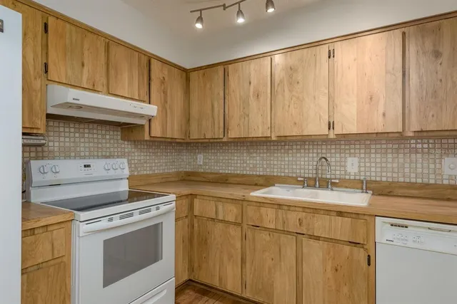 a kitchen with a sink stove and cabinets