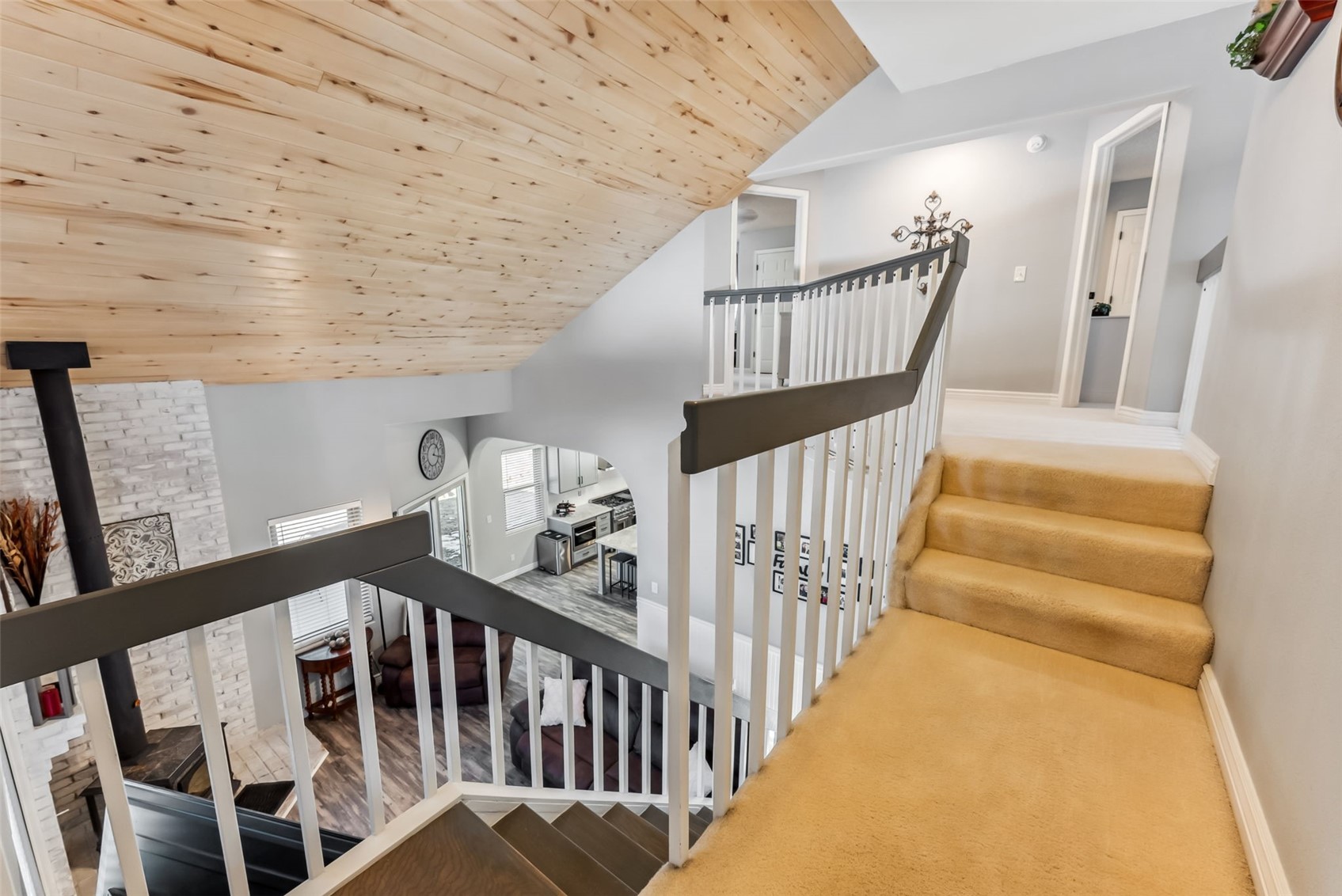 109 Old Corral Road Bailey, CO 80421 - Photo 18 of 50 Staircase featuring lofted ceiling, a wood stove, wood ceiling, and baseboards