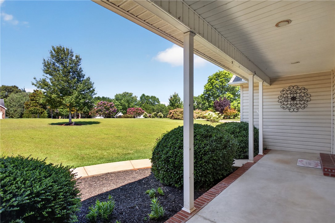 612 Providence Point Drive Seneca, SC 29678 - Photo 33 of 43 A spacious front yard with verdant lawns and manicured bushes, framed by a welcoming covered porch.