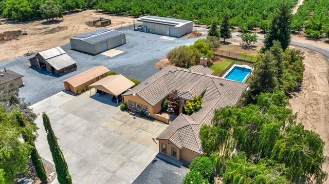a kitchen with kitchen island granite countertop stainless steel appliances lots of counter top space cabinets and a chandelier