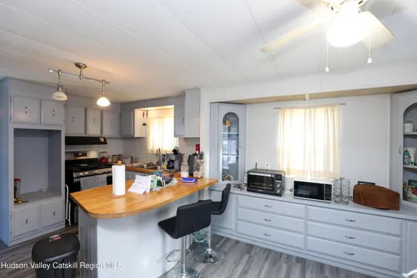 a kitchen with granite countertop a sink a counter space appliances and cabinets