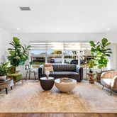 a living room with furniture potted plant and a large window
