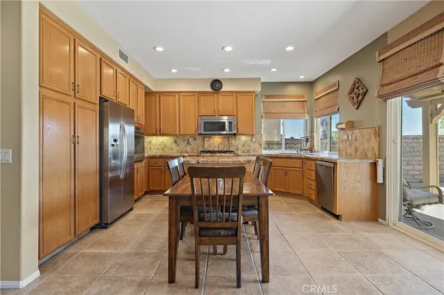 a kitchen with a table chairs refrigerator and microwave