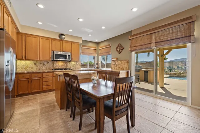 a kitchen with kitchen island granite countertop wooden cabinets a counter top space a sink and appliances