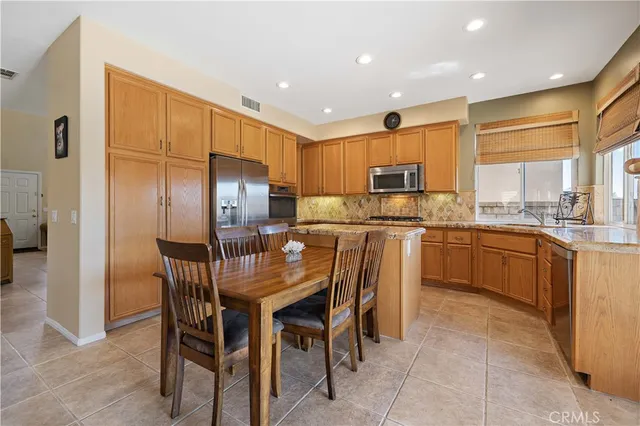 a kitchen with kitchen island granite countertop a stove cabinets and living room view