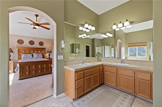 a spacious bedroom with a bed and a ceiling fan