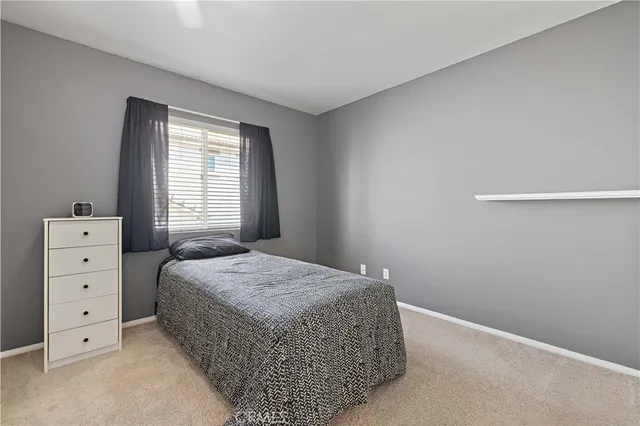 a spacious bedroom with a bed closet and a chandelier