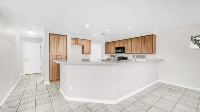 a view of kitchen with stainless steel appliances granite countertop a refrigerator sink and cabinets