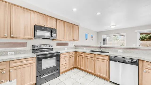 a kitchen with cabinets appliances a sink and a window