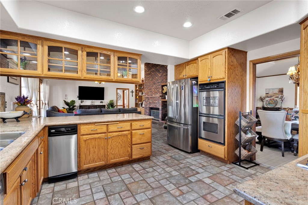 19985 Red Feather Road Apple Valley, CA 92307 - Photo 16 of 56 a kitchen with stainless steel appliances granite countertop a refrigerator and a sink