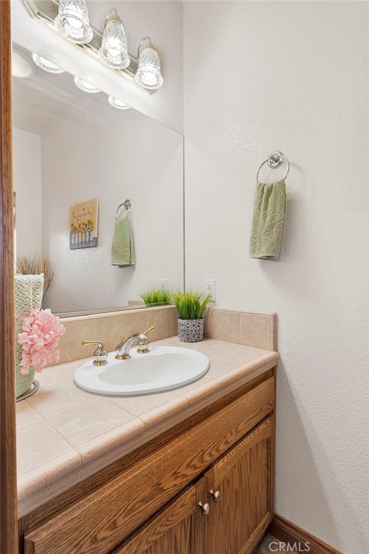 19985 Red Feather Road Apple Valley, CA 92307 - Photo 19 of 56 a bathroom with a sink vanity and mirror