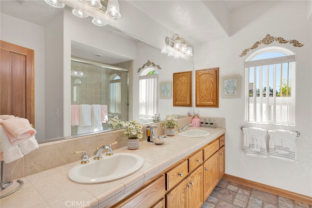 19985 Red Feather Road Apple Valley, CA 92307 - Photo 22 of 56 a bathroom with double vanity sinks a mirror and a next to a window