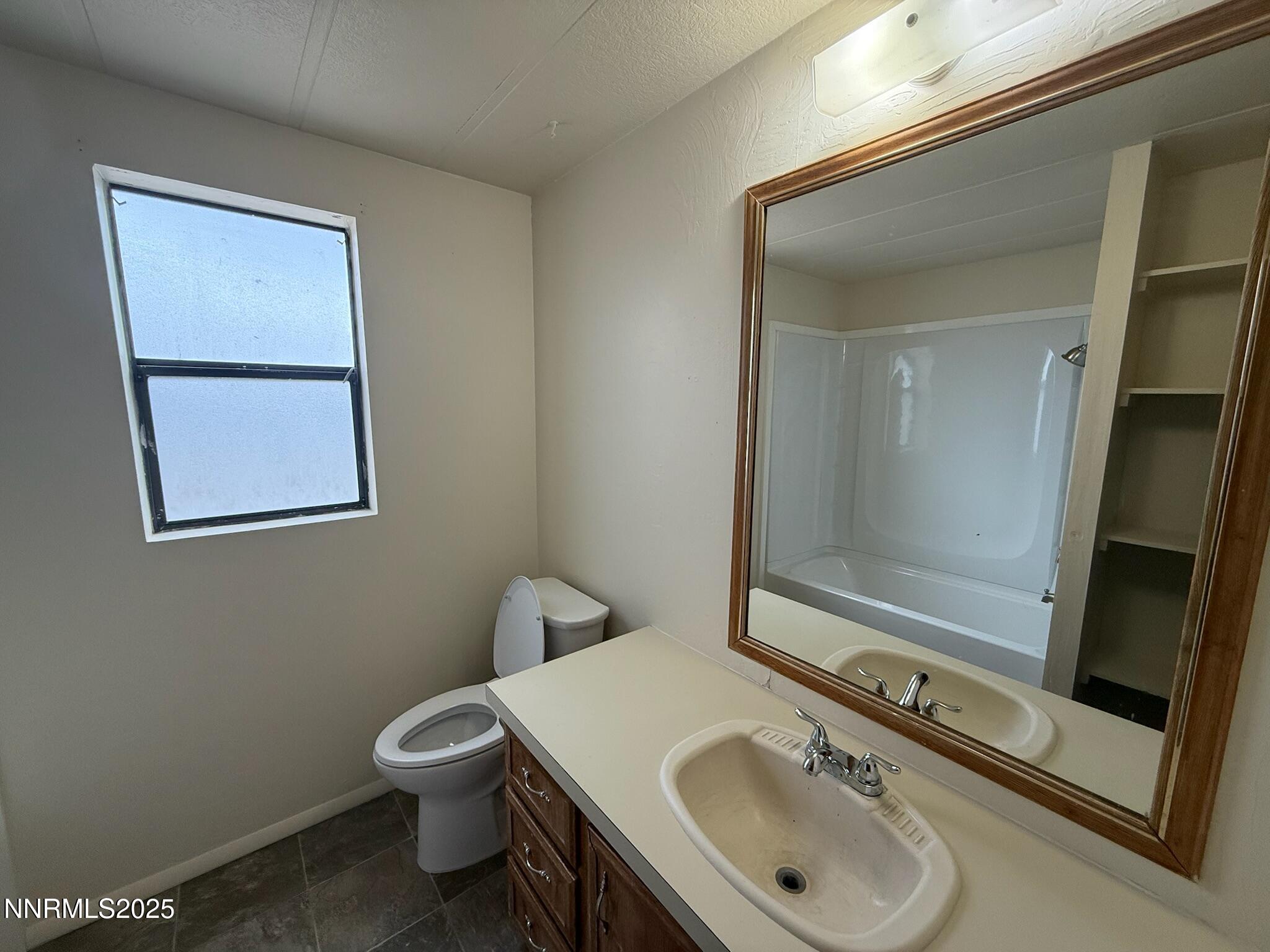 305 Kimble Drive Spring Creek, NV 89815 - Photo 31 of 31 a bathroom with a sink toilet and mirror
