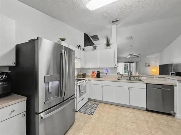a kitchen with granite countertop a refrigerator and a sink