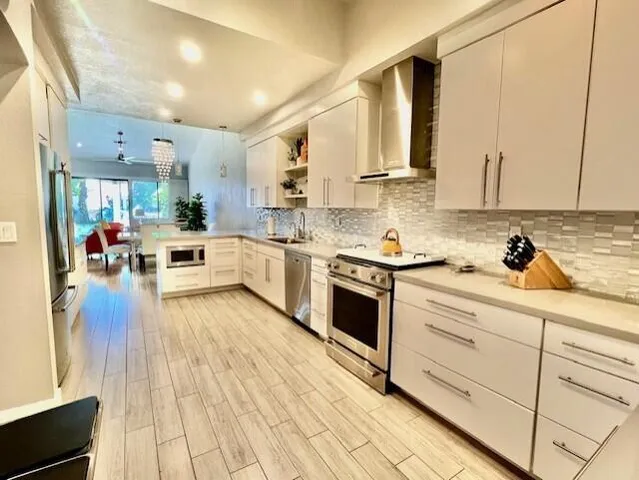 a kitchen with stainless steel appliances granite countertop a lot of counter space and wooden floors