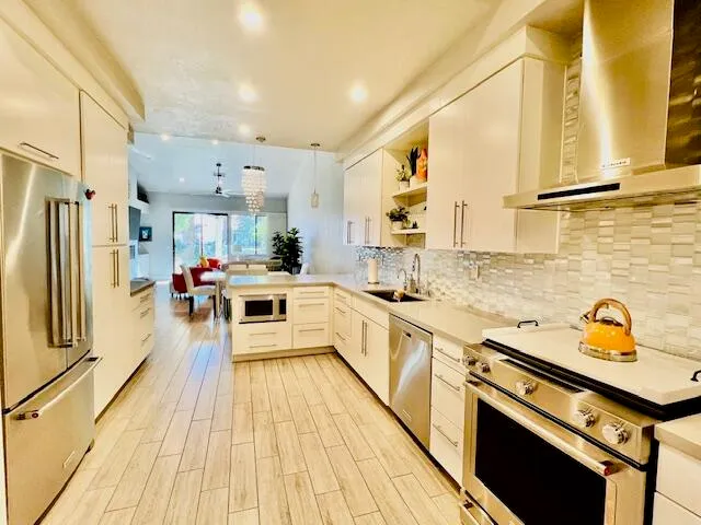 a kitchen with stainless steel appliances a stove a sink and a refrigerator