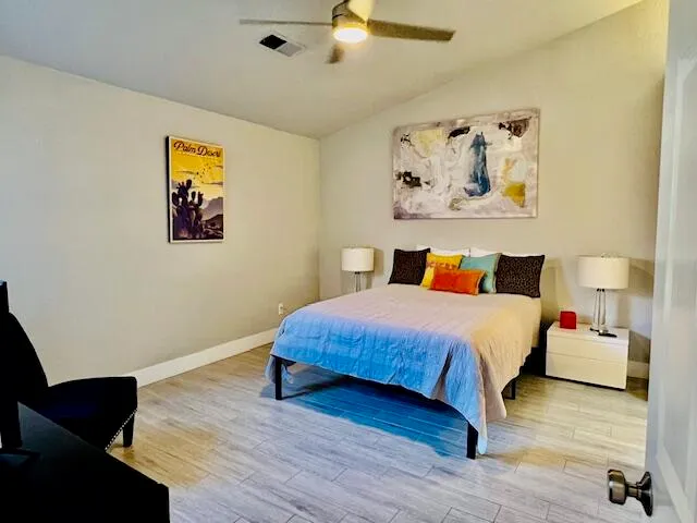 a bedroom with a bed and wooden floor