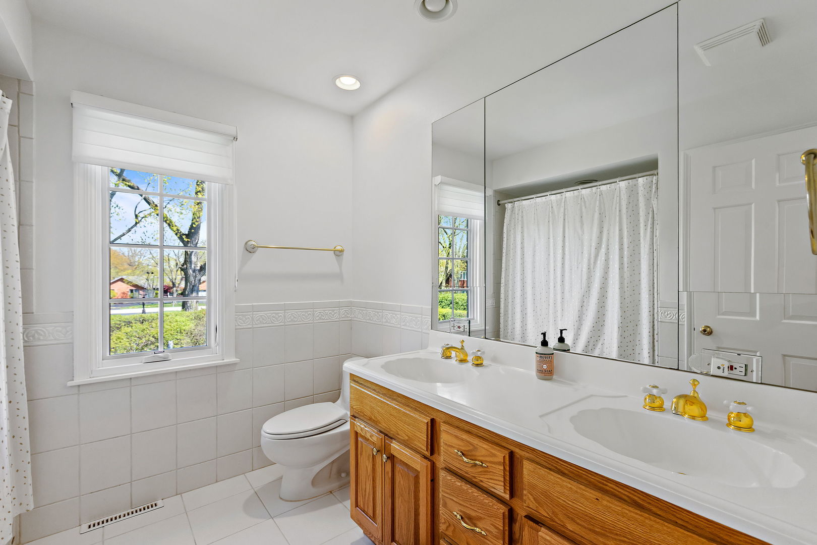 61 Coventry Road Northfield, IL 60093 - Photo 22 of 28 a bathroom with a granite countertop sink a toilet a mirror and shower