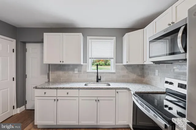 a kitchen with stainless steel appliances granite countertop a sink stove and cabinets