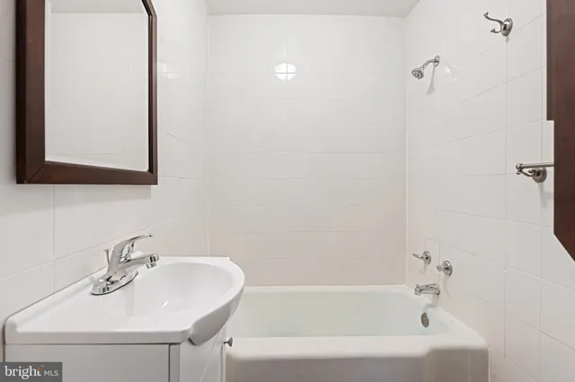a white bath tub sitting next to a white sink