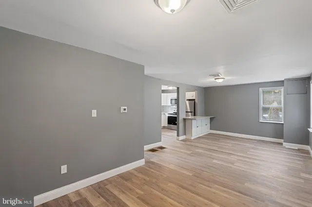 a view of empty room with wooden floor